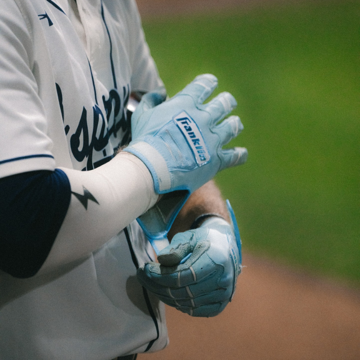 Close-up of UNF Ospreys baseball glove with player preparing for batting