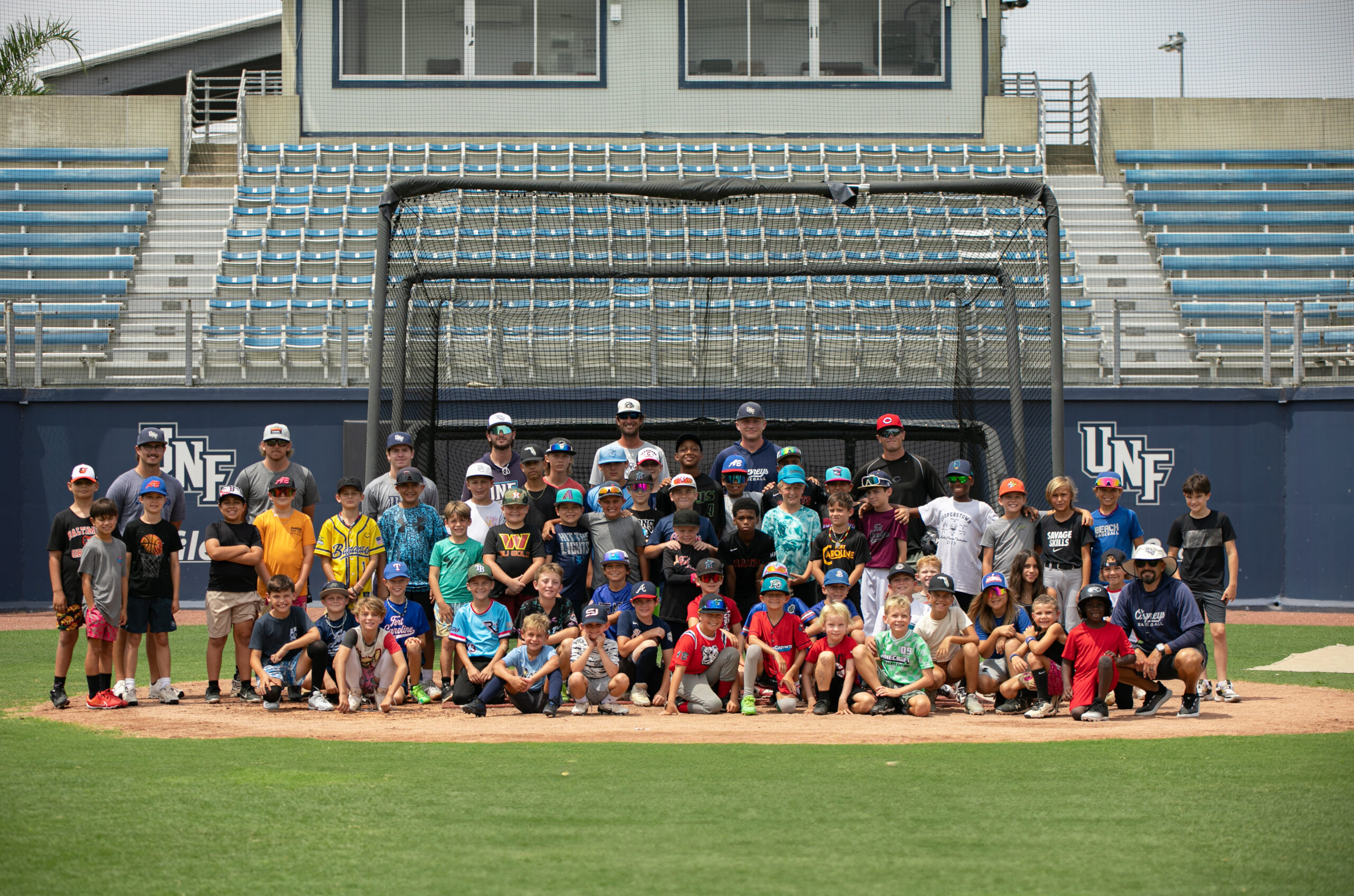 UNF Baseball youth campers and staff posing for a photo at Harmon Stadium.