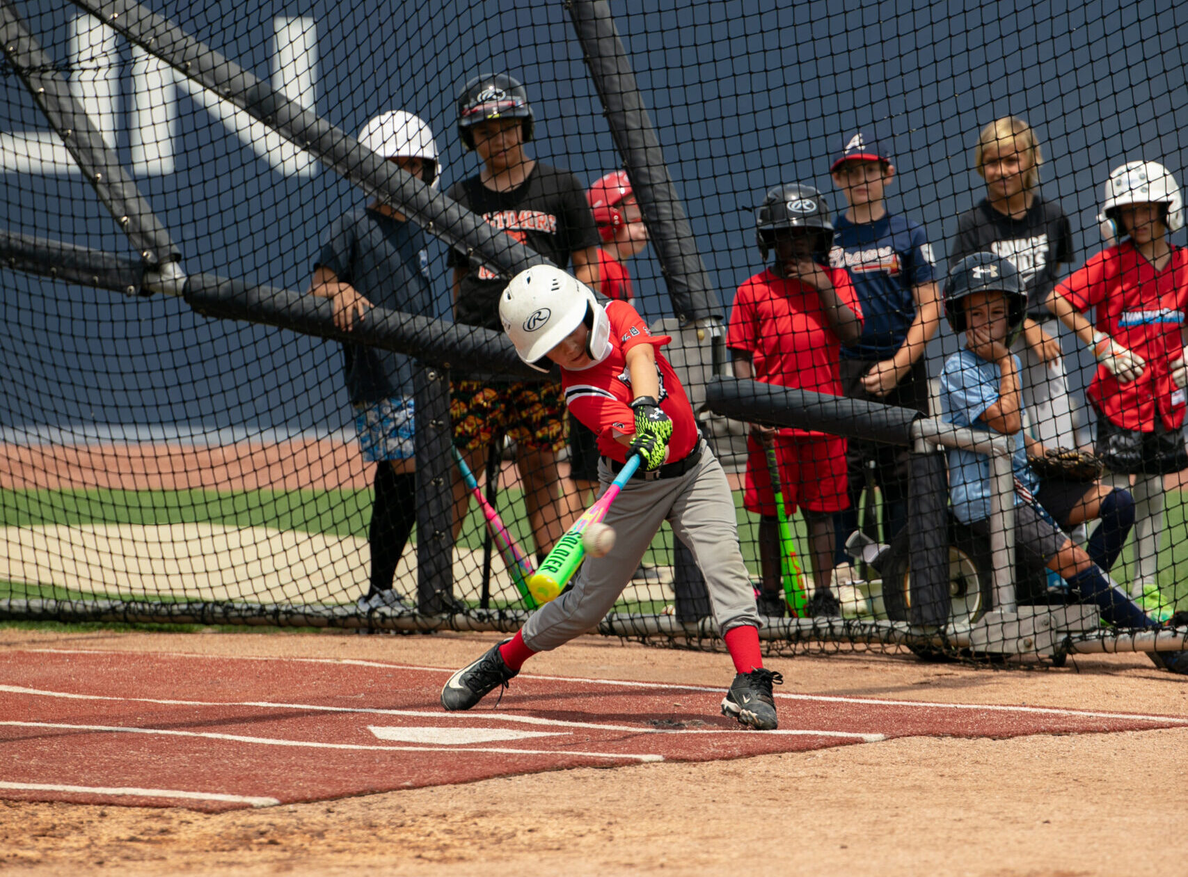 Young baseball player swings the bat during baseball hitting training in Jacksonville Florida at a UNF baseball camp.