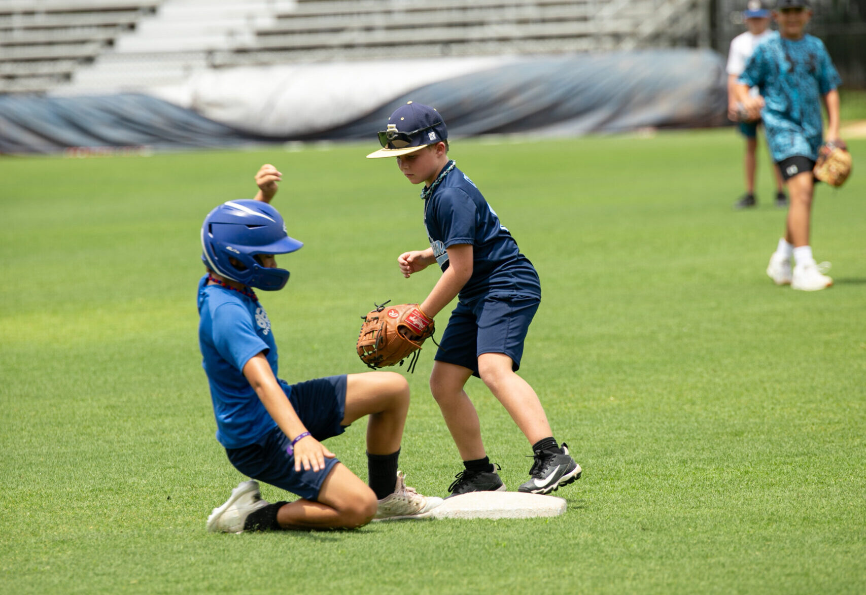 two youth baseball players make a play during baseball training in jacksonville fl at a UNF youth baseball camp