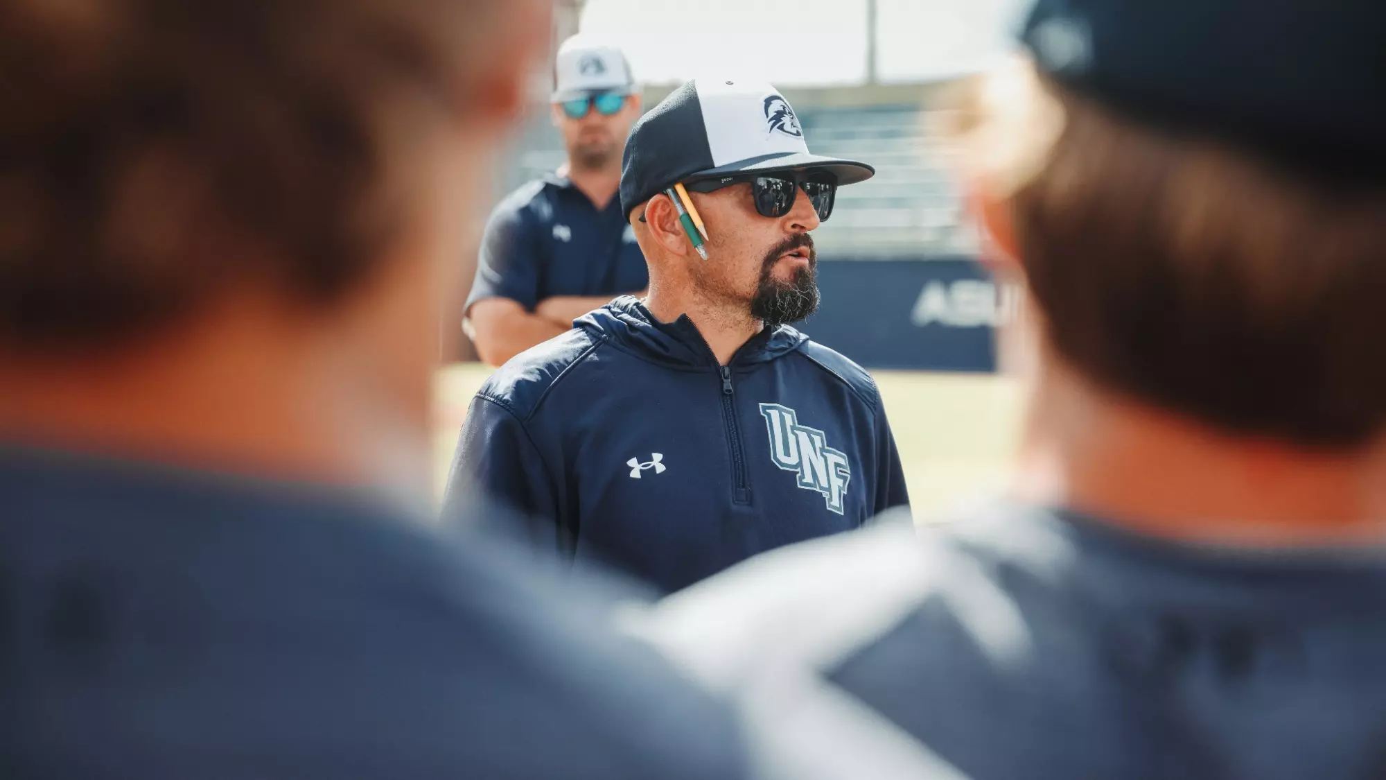 UNF Head Coach Joe Mercadante coaching players at UNF Baseball